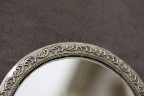 A beautiful, vintage ladies round chrome hand held vanity mirror with lovely detailing on the back.