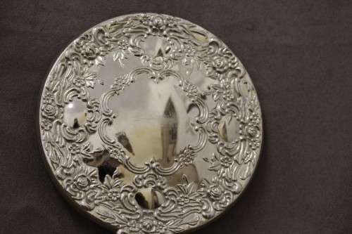 A beautiful, vintage ladies round chrome hand held vanity mirror with lovely detailing on the back.