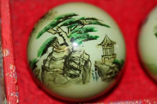 A stunning boxed set of hand painted, scenery themed Chinese cloisonne enamelled Ben-wa balls
