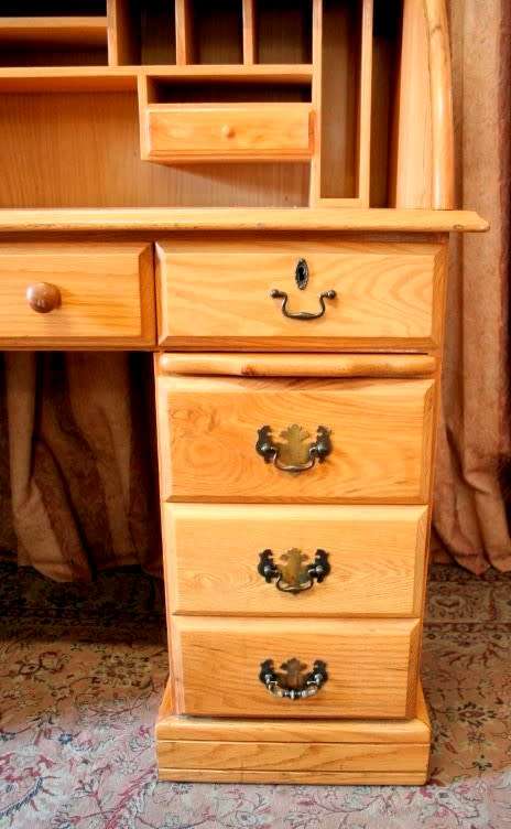 An exquisite Oak roll-top writing bureau with nine drawers, brass handles and pigeon holes.
