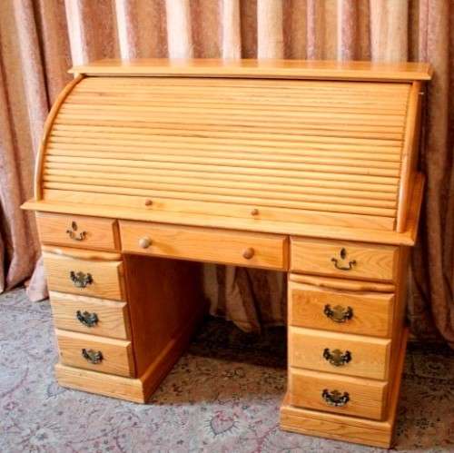 An exquisite Oak roll-top writing bureau with nine drawers, brass handles and pigeon holes.