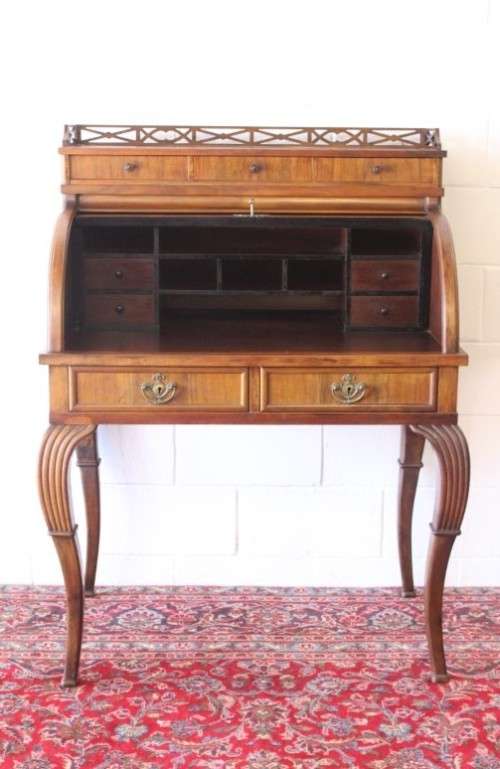 A magnificently made walnut barrel-roll top writing desk with an array of drawers and pigeon holes