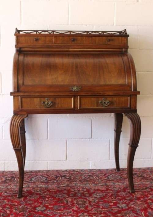 A magnificently made walnut barrel-roll top writing desk with an array of drawers and pigeon holes