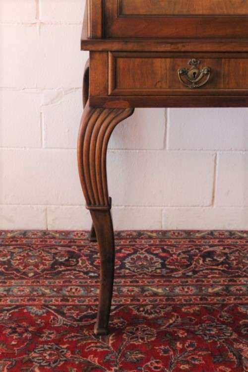 A magnificently made walnut barrel-roll top writing desk with an array of drawers and pigeon holes