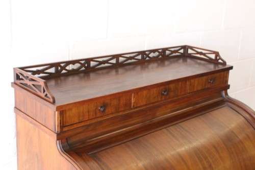 A magnificently made walnut barrel-roll top writing desk with an array of drawers and pigeon holes