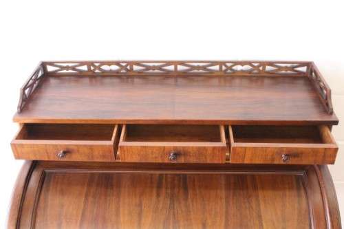 A magnificently made walnut barrel-roll top writing desk with an array of drawers and pigeon holes