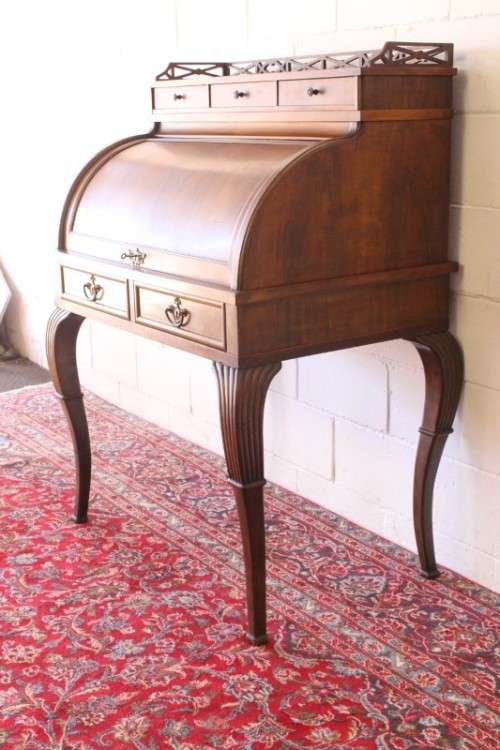 A magnificently made walnut barrel-roll top writing desk with an array of drawers and pigeon holes