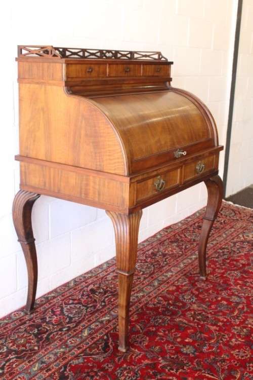 A magnificently made walnut barrel-roll top writing desk with an array of drawers and pigeon holes