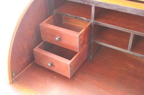 A magnificently made walnut barrel-roll top writing desk with an array of drawers and pigeon holes