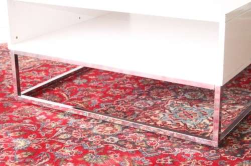 A stunning and modern white square coffee table with a magazine/ book shelf on chromed table legs