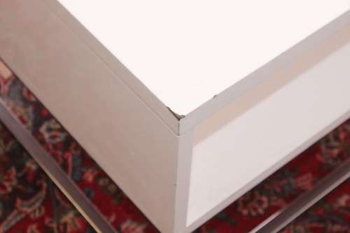 A stunning and modern white square coffee table with a magazine/ book shelf on chromed table legs
