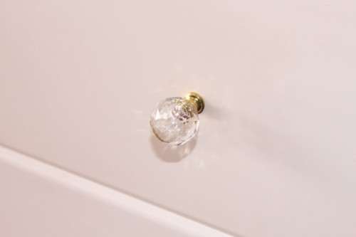 A stunning white 5-drawer chest of drawers with crystal/ glass? handles and ample storage space