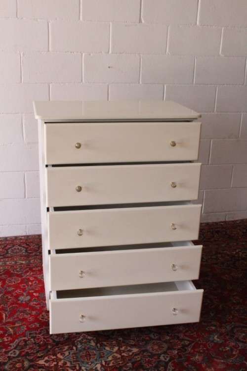 A stunning white 5-drawer chest of drawers with crystal/ glass? handles and ample storage space
