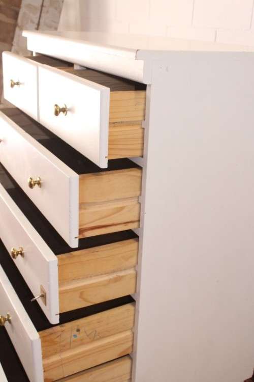 A tall 4-over-2 white painted chest of drawers with brass handles and ample storage space