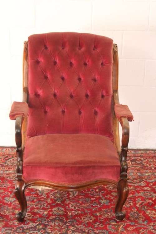 A stunningly hand carved antique walnut "Art Nouveau" reading chair with deep button detailing