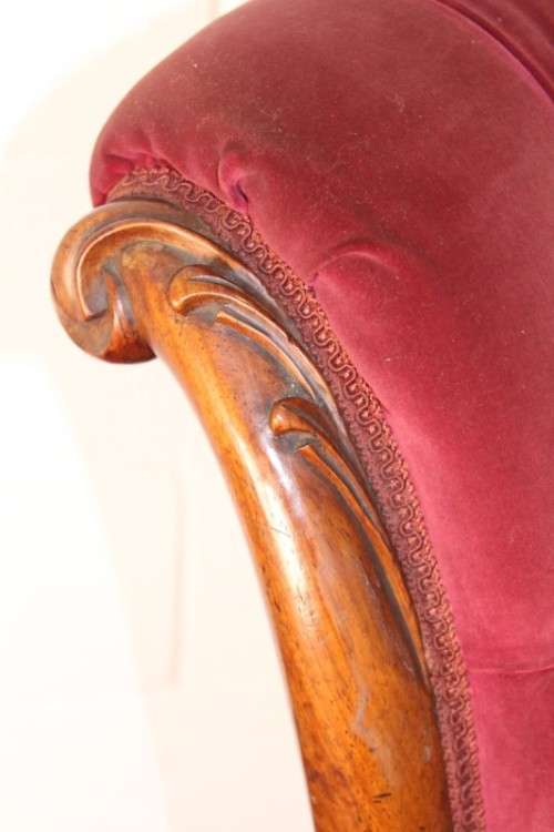 A stunningly hand carved antique walnut "Art Nouveau" reading chair with deep button detailing