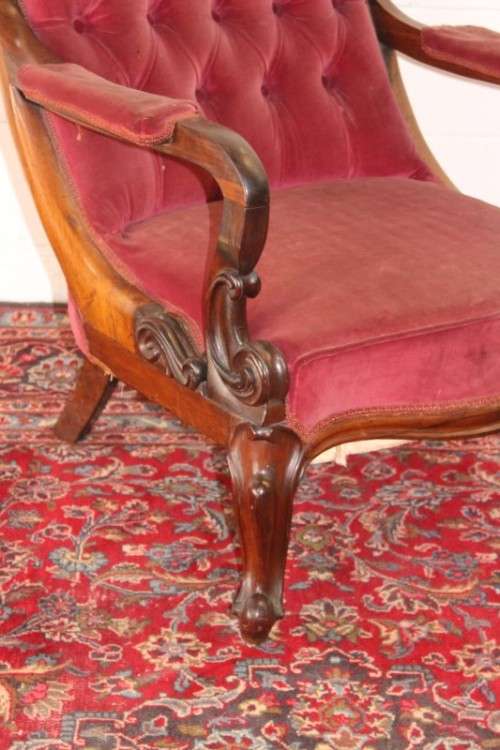A stunningly hand carved antique walnut "Art Nouveau" reading chair with deep button detailing