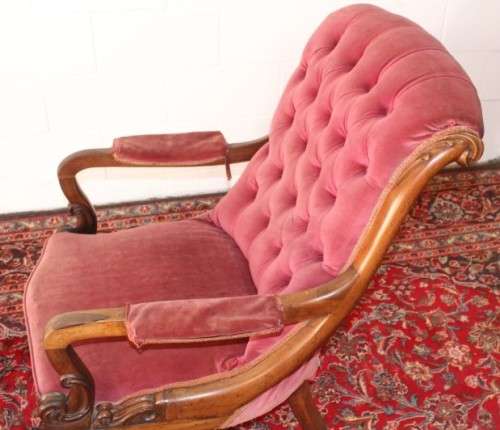 A stunningly hand carved antique walnut "Art Nouveau" reading chair with deep button detailing