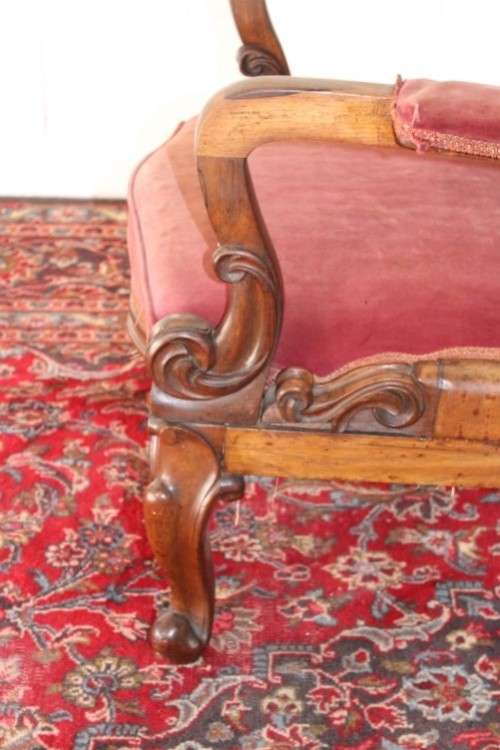 A stunningly hand carved antique walnut "Art Nouveau" reading chair with deep button detailing