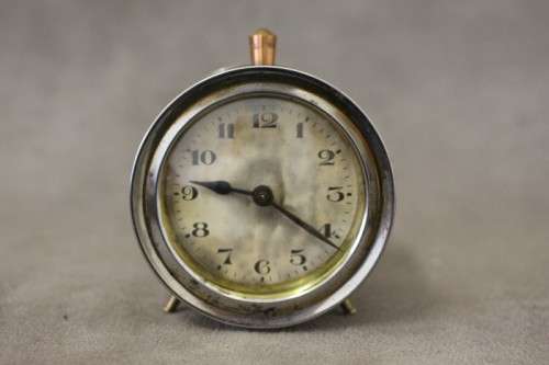 A gorgeous vintage mini round silver metal wind up clock, working.