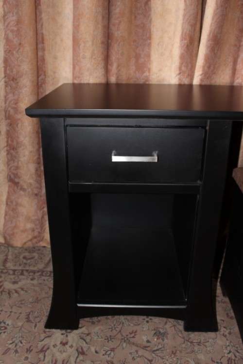 A stunning modern styled black wooden dressing table with two drawers and a suede stool.