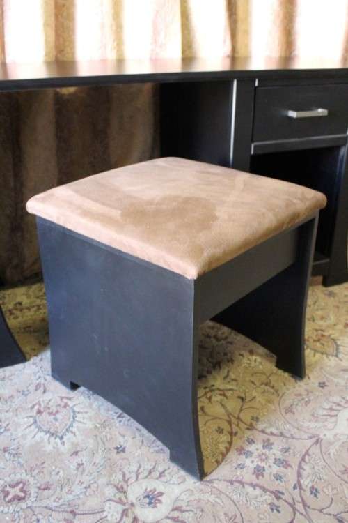 A stunning modern styled black wooden dressing table with two drawers and a suede stool.