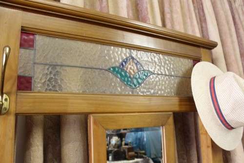 A gorgeous light wood hall stand with a coloured stained glass top, centre mirror and storage drawer