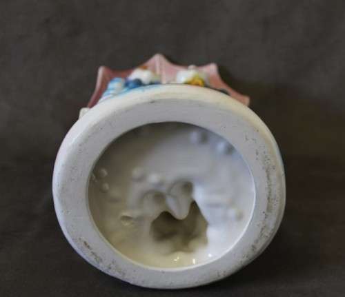 A beautiful porcelain figurine of a young boy and girl under an umbrella, fabulous on display.
