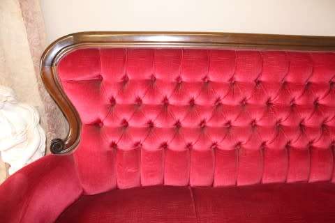 A gorgeous antique Victorian 3 seater settee couch w carved detailing and period style upholstery.