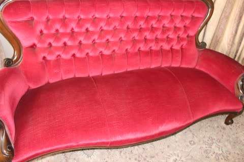 A gorgeous antique Victorian 3 seater settee couch w carved detailing and period style upholstery.