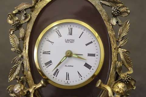 A beautiful vintage Japanese brass "Landex" wind up alarm clock with cherubs, working.