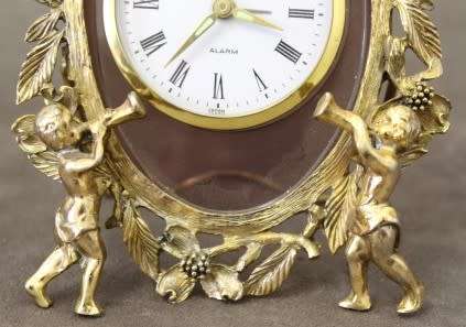 A beautiful vintage Japanese brass "Landex" wind up alarm clock with cherubs, working.