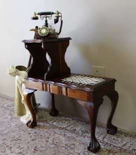 A gorgeous Imbuia ball and claw telephone table with riempies and storage under the seat.