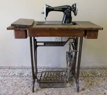 A remarkable antique singer sewing machine oak & cast iron stand with a Harrison sewing machine in.