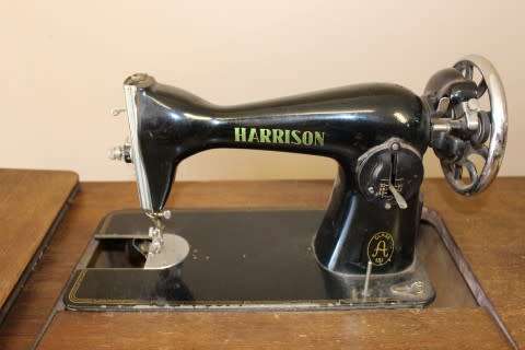 A remarkable antique singer sewing machine oak & cast iron stand with a Harrison sewing machine in.