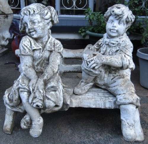 A gorgeous little concrete bench with two children sitting on it. Stunning in a garden!