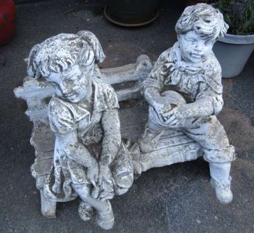 A gorgeous little concrete bench with two children sitting on it. Stunning in a garden!