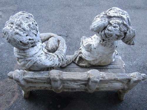 A gorgeous little concrete bench with two children sitting on it. Stunning in a garden!
