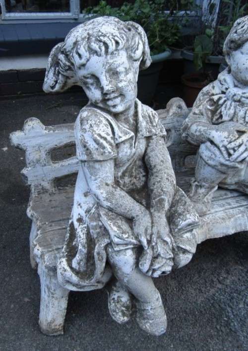 A gorgeous little concrete bench with two children sitting on it. Stunning in a garden!
