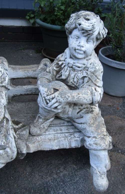 A gorgeous little concrete bench with two children sitting on it. Stunning in a garden!