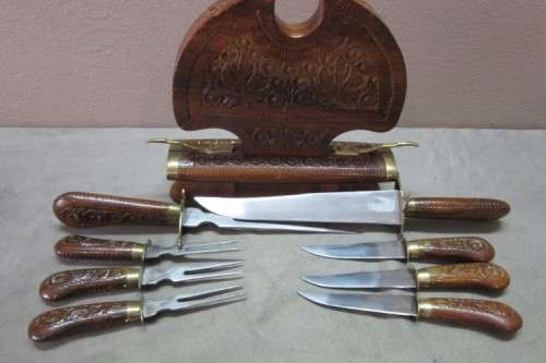 An awesome collectible hand carved Indian knife and fork carving set in a wood stand w/ brass trim