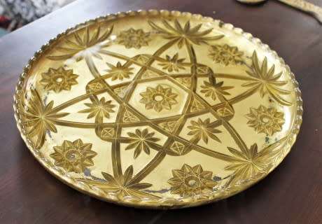 An eye-catching, round gold-coloured glass tray, with a beautiful pattern. Perfect on display!