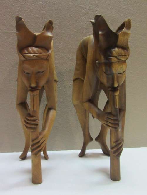 A lovely pair of Balinese carvings of men playing a flute. Great on display.