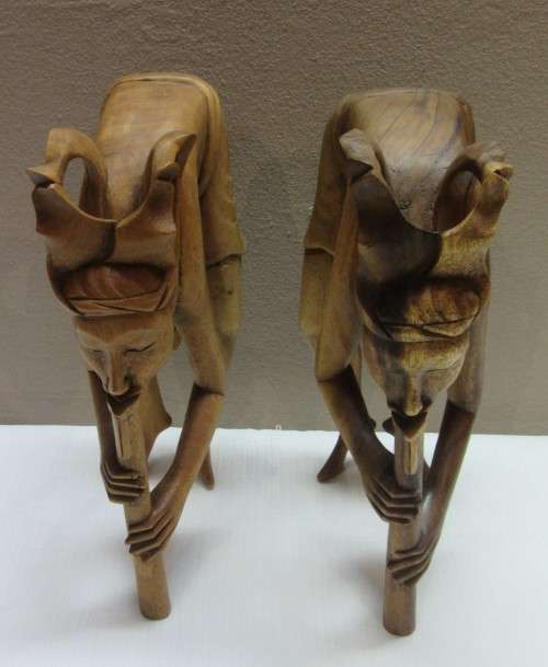 A lovely pair of Balinese carvings of men playing a flute. Great on display.