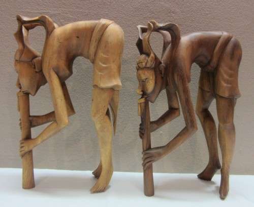 A lovely pair of Balinese carvings of men playing a flute. Great on display.