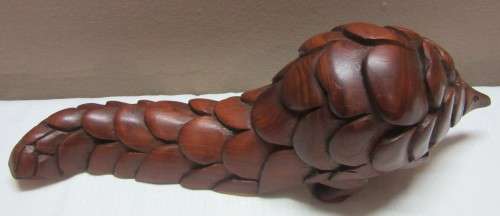 A lovely wooden hand carving of a Pangolin great on display or added to a collection.