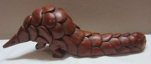 A lovely wooden hand carving of a Pangolin great on display or added to a collection.