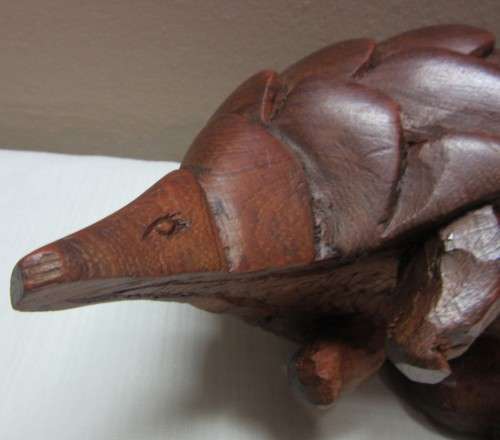 A lovely wooden hand carving of a Pangolin great on display or added to a collection.