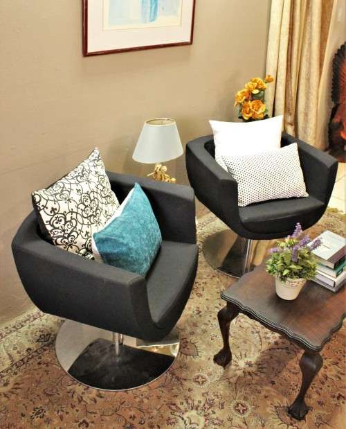 A stylish & modern pair of sleek, retro-styled black arm chairs, with thick durable fabric.