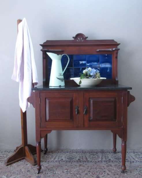 A wonderful vintage solid Oak double door wash stand with a black marble top on castors - stunning!!